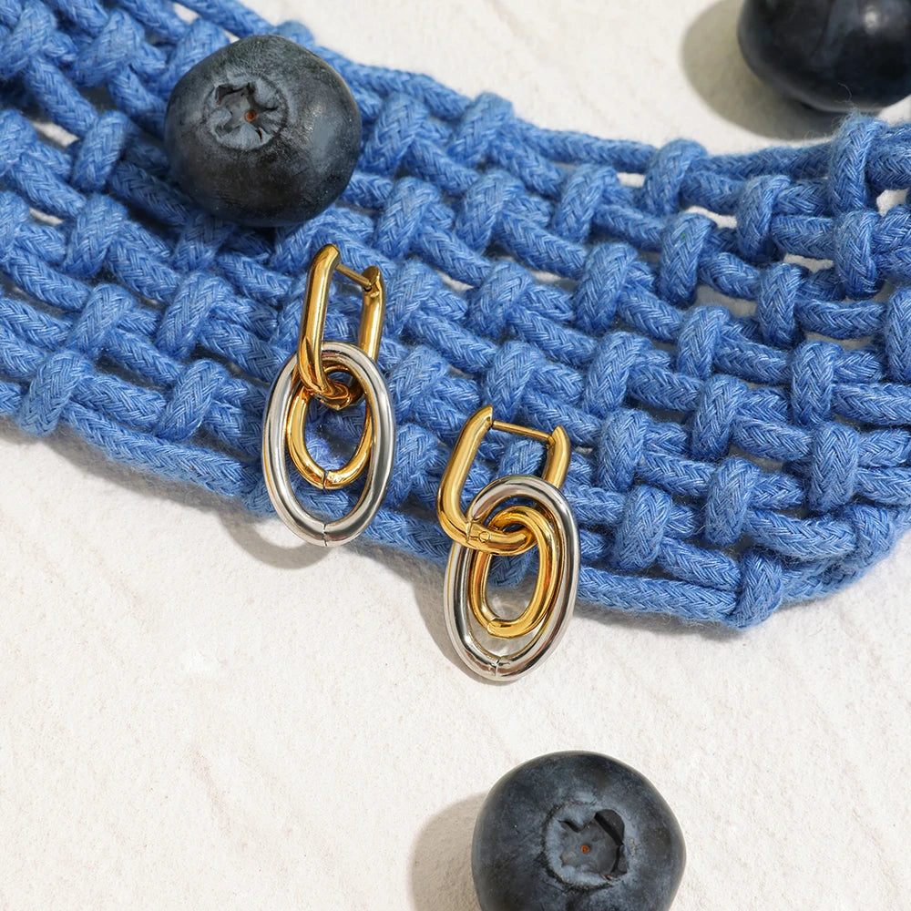 Gold-silberne Ohrringe aus PVD 18K vergoldetem Edelstahl auf blauem Strick | moderner Ohrschmuck