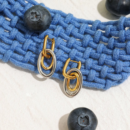 Gold-silberne Ohrringe aus PVD 18K vergoldetem Edelstahl auf blauem Strick | moderner Ohrschmuck