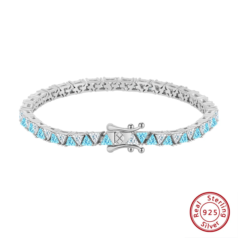 Freigestelltes Tennisarmband aus 925er Sterling Silber, durchgängig besetzt mit leuchtend hellblauen AAAAA Zirkonia-Steinen, mit dem detailreichen Verschluss prominent platziert. Das 'Real 925 Sterling Silver' Echtheitssiegel ist unten rechts sichtbar.