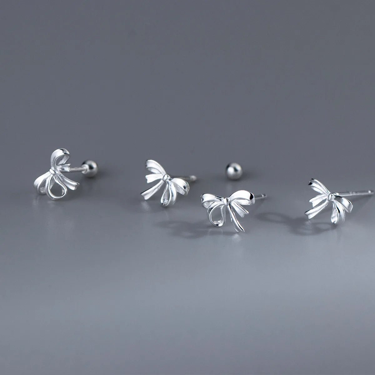 Schleifen-Ohrstecker aus hochreinem 999 Feinsilber im Überblick: Klassische Motiv-Ohrringe mit Stecker und Kugelverschluss und Steckverschluss.