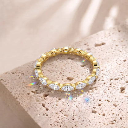 Rundum besetzter Eternity-Ring aus 14 Karat vergoldetem Silber mit strahlenden Marquise-Zirkoniasteinen auf beigem Naturstein.