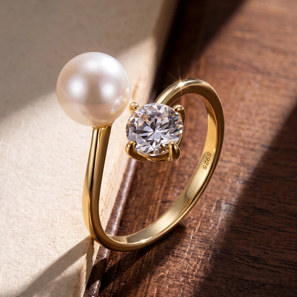Verstellbarer Toi-et-Moi-Ring aus 14 Karat vergoldetem Silber mit Süßwasserperle und Zirkonia-Stein stilvoll auf Holz präsentiert.