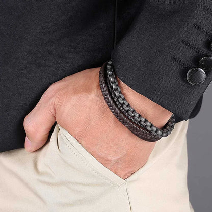 Ein Mann mit den Händen in der Hosentasche trägt das breite, mehrlagige Biker-Armband aus Leder und Edelstahl passend zum eleganten Sakko.