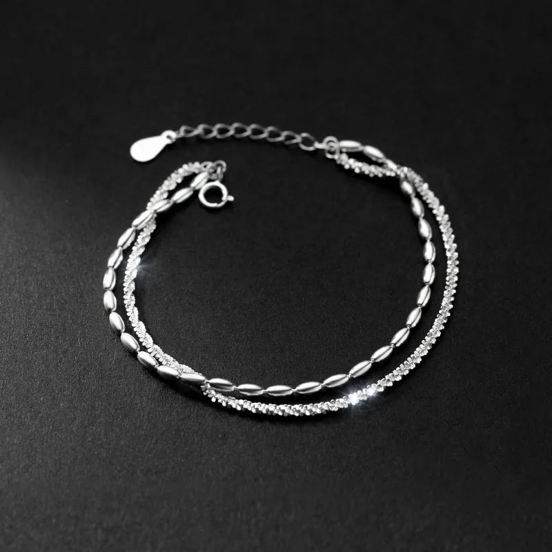 Minimalistisches doppelreihiges Silberarmband mit Federringverschluss und Verlängerungskette edel inszeniert auf schwarzem Grund