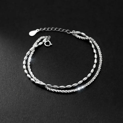 Minimalistisches doppelreihiges Silberarmband mit Federringverschluss und Verlängerungskette edel inszeniert auf schwarzem Grund