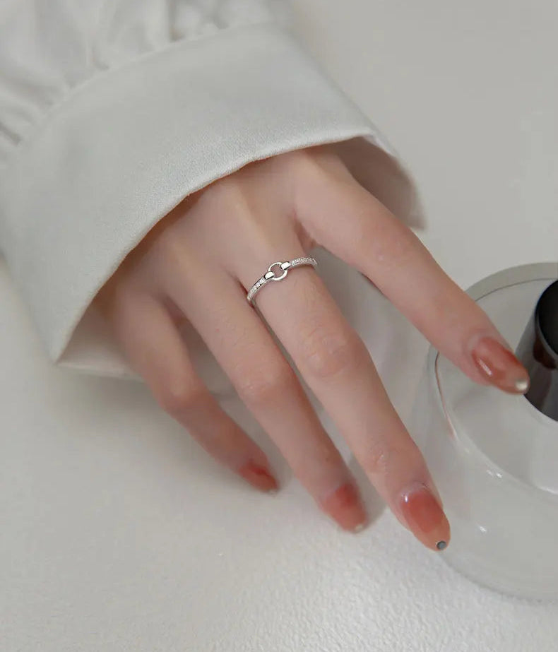 Nahaufnahme einer Hand, die die rein silberne Variante des verstellbaren 925er Sterling Silber Rings mit glitzerndem Zirkonia-Besatz trägt.