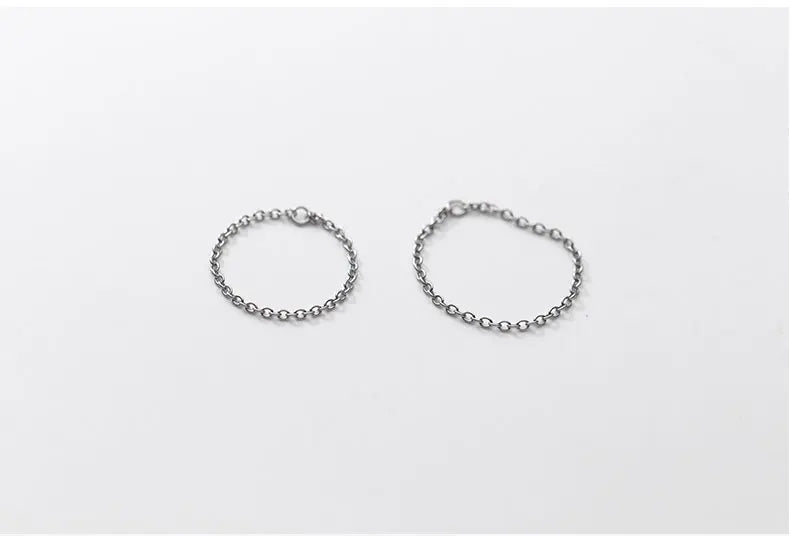 Zwei filigrane Gliederketten-Ringe aus 925er Silber mit Platin-Plattierung im Vergleich nebeneinander auf weißer Fläche.