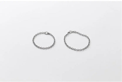 Zwei filigrane Gliederketten-Ringe aus 925er Silber mit Platin-Plattierung im Vergleich nebeneinander auf weißer Fläche.