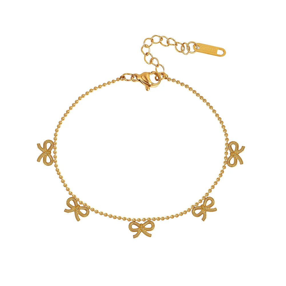 Produktfreisteller des 18K vergoldeten Edelstahl-Armbands mit kleinen Schleifen-Anhängern auf weißem Hintergrund.