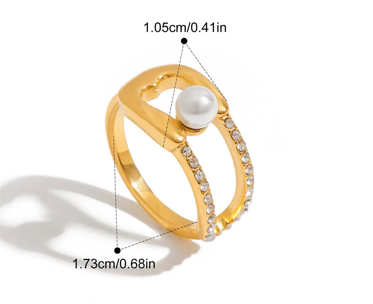 Technische Zeichnung eines goldfarbenen Rings mit Abmessungen, 1,85 cm Höhe und 1,7 cm Breite. Das Bild zeigt Strasssteine und eine Perle.