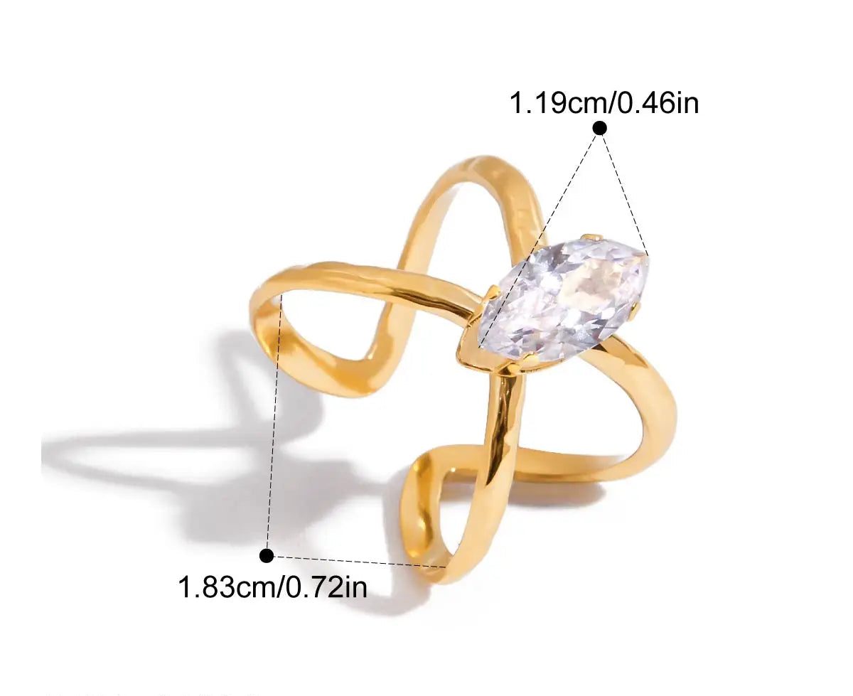 Grafische Darstellung eines goldenen Rings mit 18K PVD-Vergoldung. Er hat ein lineares, sich kreuzendes Design und ist mit einem großen, klaren Zirkonia Stein besetzt. Die Maße sind ebenfalls angegeben mit einem Innendurchmesser von 1,83 cm und einer Steinbreite von 1,19 cm.