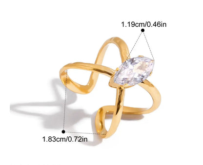 Grafische Darstellung eines goldenen Rings mit 18K PVD-Vergoldung. Er hat ein lineares, sich kreuzendes Design und ist mit einem großen, klaren Zirkonia Stein besetzt. Die Maße sind ebenfalls angegeben mit einem Innendurchmesser von 1,83 cm und einer Steinbreite von 1,19 cm.