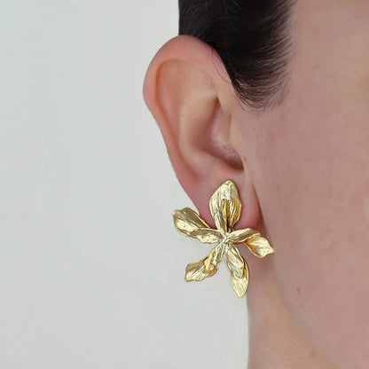Große goldene Blumen-Ohrringe aus PVD 18K vergoldetem Edelstahl an Ohr getragen | Statement-Ohrringe