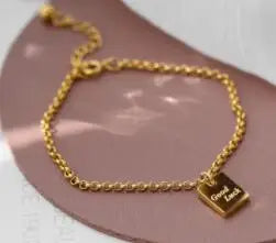 Detailansicht des 18K vergoldeten Gliederketten-Armbands mit graviertem „Good Luck“-Anhänger.
