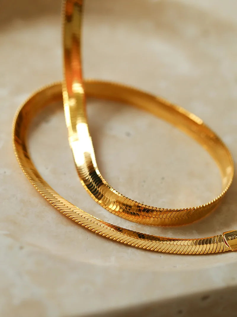 Nahaufnahme einer goldenen Schlangenkette mit Glanzeffekt | goldene Kette flach | vergoldeter Schmuck für Frauen