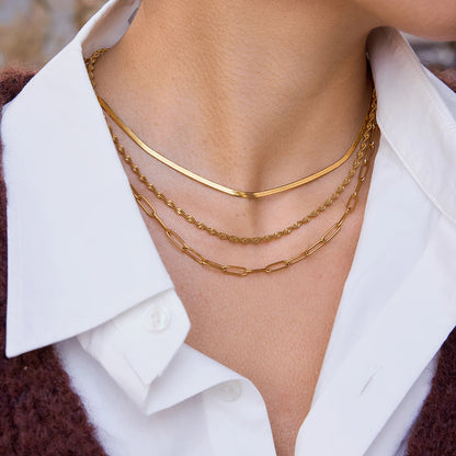 Detailaufnahme des dreireihigen goldenen Halsketten-Sets aus 18K vergoldetem Edelstahl am Dekolleté.