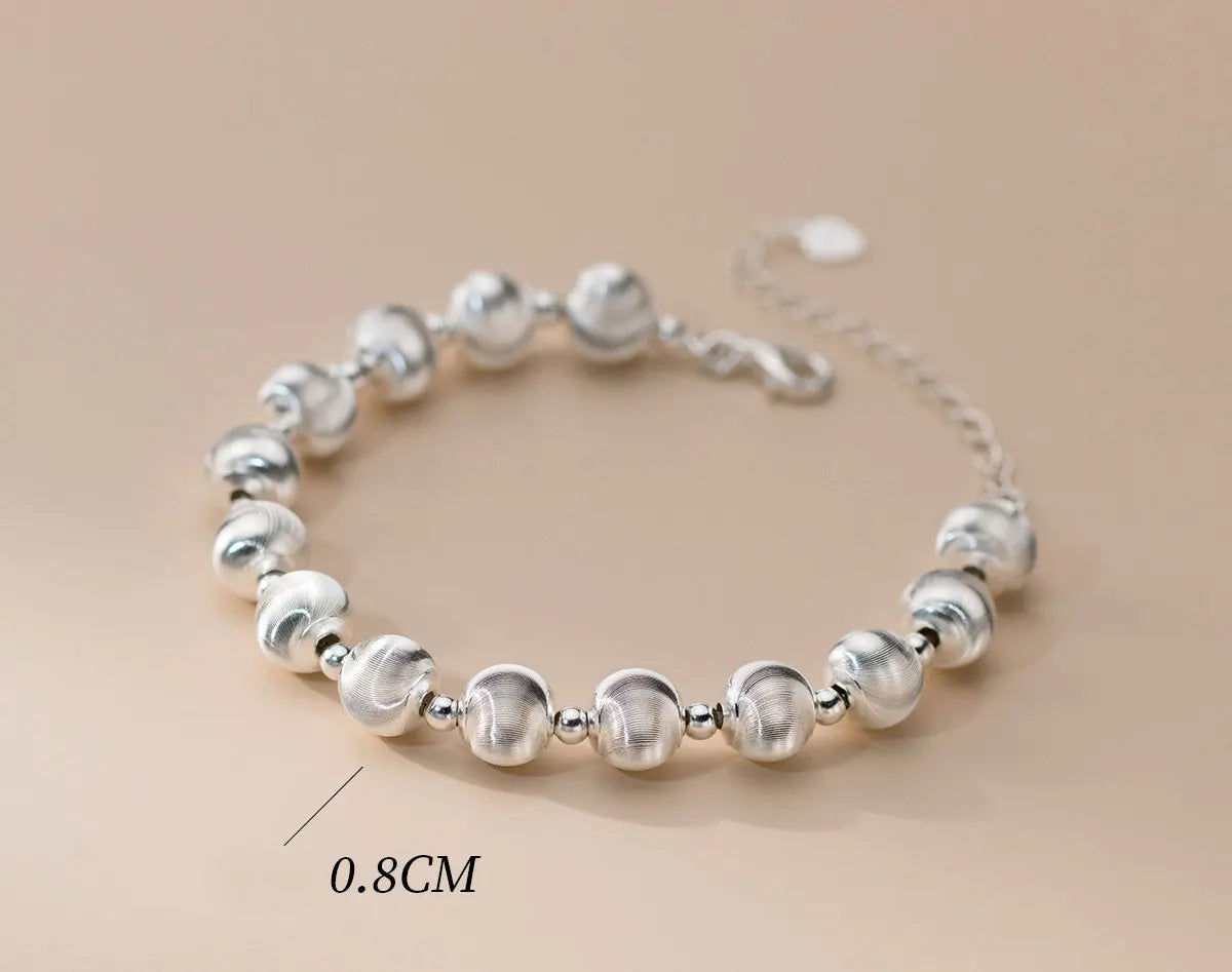 Armband aus 925er Sterling Silber mit Kugelperlen (mattiert und glänzend), liegend auf hellem Untergrund, mit einer Maßangabe von 0.8CM für den Perlengröße.