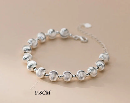 Armband aus 925er Sterling Silber mit Kugelperlen (mattiert und glänzend), liegend auf hellem Untergrund, mit einer Maßangabe von 0.8CM für den Perlengröße.