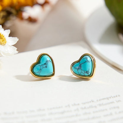 Paar Herz-Ohrstecker aus Edelstahl mit 18K PVD Vergoldung und blauem Türkisstein auf Buch