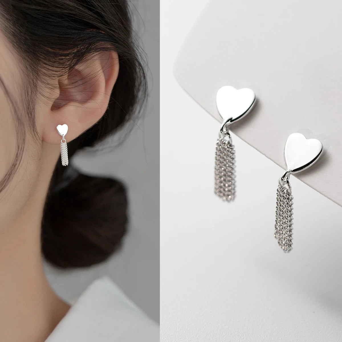 Seitenprofil einer Frau mit hochgestecktem Haar, die einen eleganten Herz-Ohrring aus 925er Sterling Silber mit fein herabhängenden Fransenketten trägt.